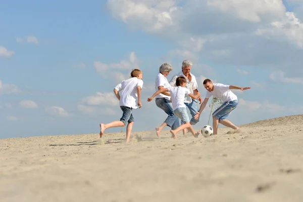 Família jogando futebol em uma praia — Fotografia de Stock