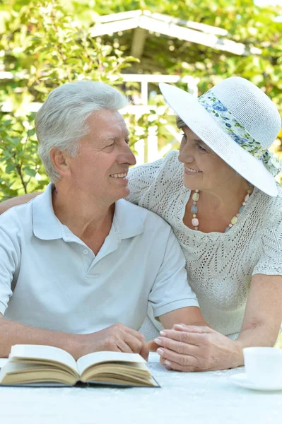 Casal sênior lendo um livro — Fotografia de Stock