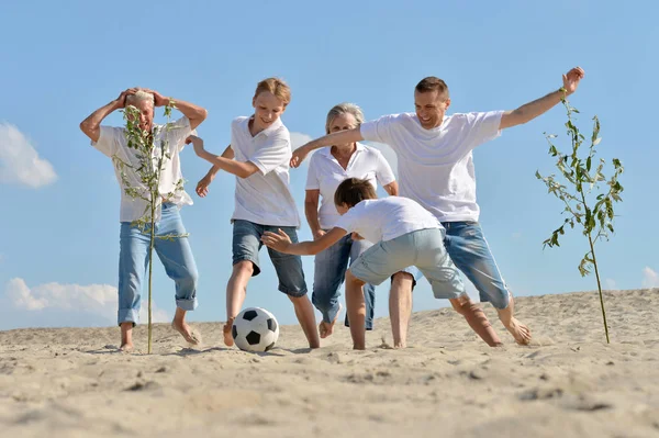 Família jogando futebol em uma praia — Fotografia de Stock