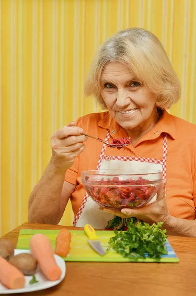 Senior vrouw eten plantaardige salade — Stockfoto