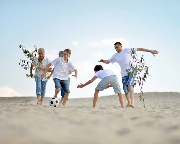 Rodina hrát fotbal na pláži — Stock fotografie
