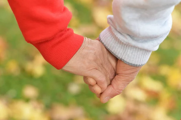 Пожилая пара держится за руки — стоковое фото