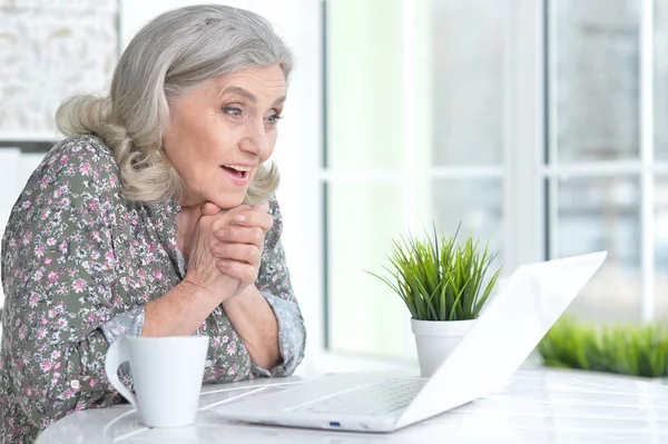 Femme âgée émotionnelle avec ordinateur portable — Photo