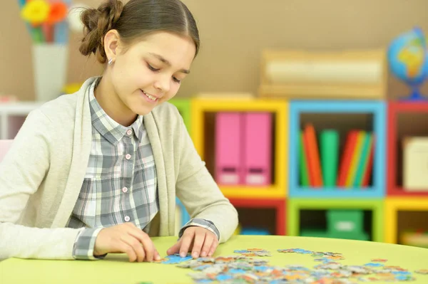 Tiener meisje verzamelen puzzelstukjes — Stockfoto
