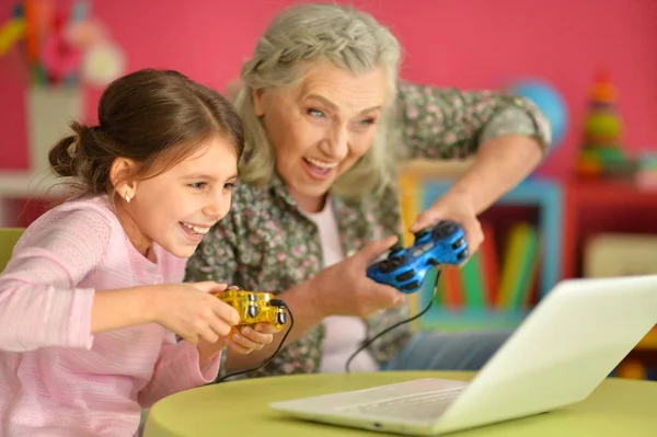 Abuela y nieta jugando en el ordenador portátil —  Fotos de Stock