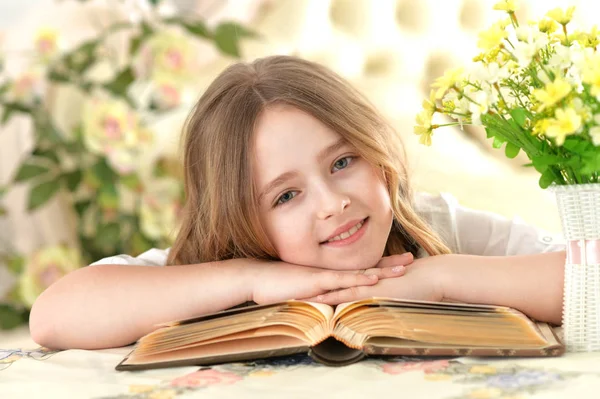 Girl lying on big opened book — Stock Photo, Image