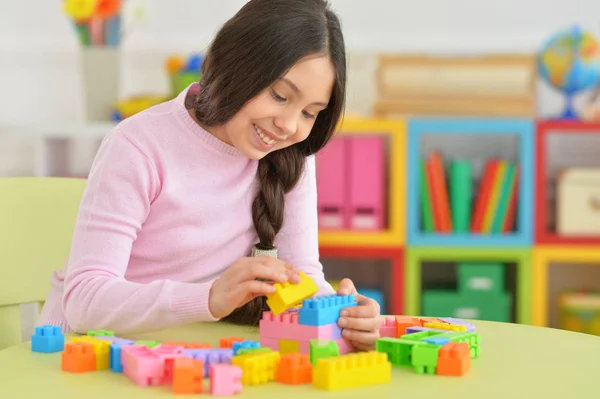 Kleines Mädchen mit bunten Plastikklötzen — Stockfoto