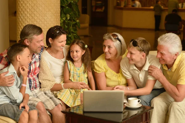 Rodzina siedzi w pobliżu tabeli z laptopa — Zdjęcie stockowe
