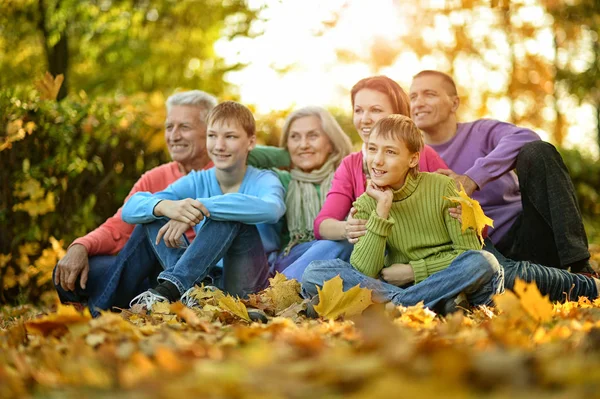 Stor familj sitter på marken — Stockfoto