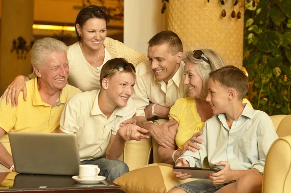 Familia sentada con dispositivos digitales — Foto de Stock