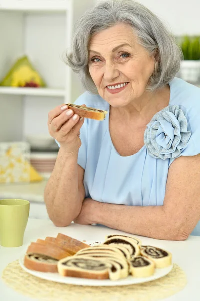 Mulher idosa comer biscoitos — Fotografia de Stock