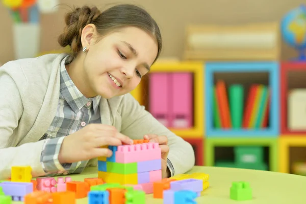 Teenage girl playing with plastic blocks — Stock Photo, Image