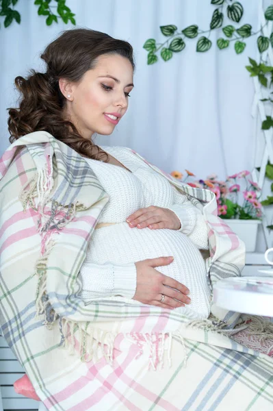 怀孕的女人坐在桌旁 — 图库照片