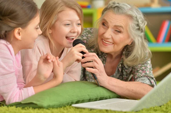 Senior vrouw met kleindochters laptop gebruikt — Stockfoto