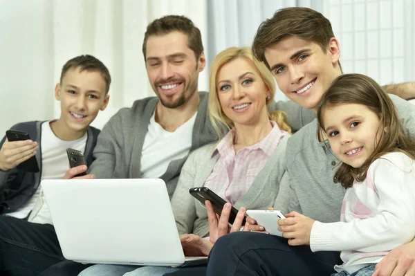 Family sitting on couch with laptop — Stock Photo, Image