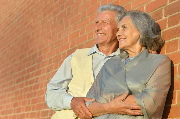 Пожилая пара позирует по зданиям — стоковое фото
