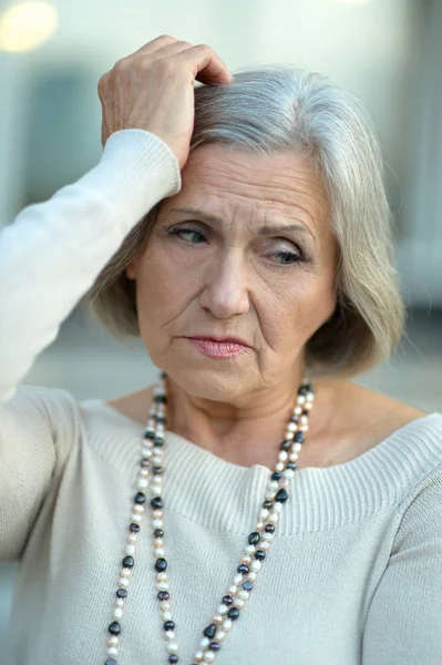 Старшая женщина с головной болью — стоковое фото