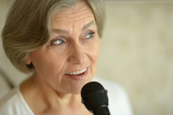 Senior woman singing with microphone — Stock Photo, Image