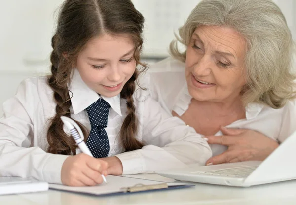 Mormor och barnbarn gör läxor — Stockfoto