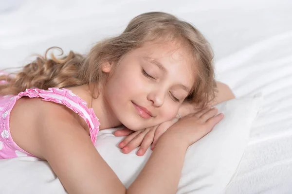 Liten flicka sover i sängen — Stockfoto