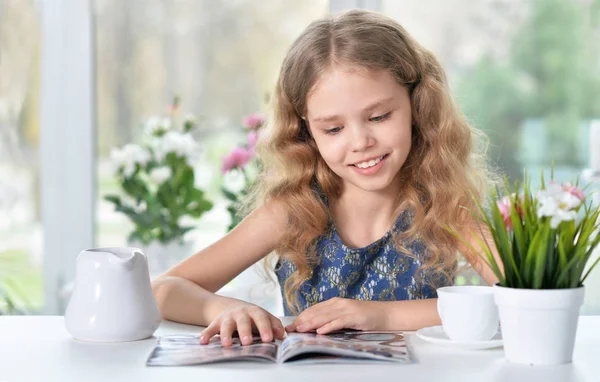 Kleines Mädchen liest Zeitschrift — Stockfoto