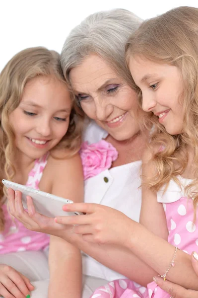 Abuelita con nietas usando smartphone — Foto de Stock