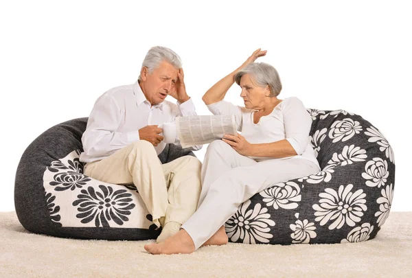 Couple sitting in armchairs with newspaper — Stock Photo, Image