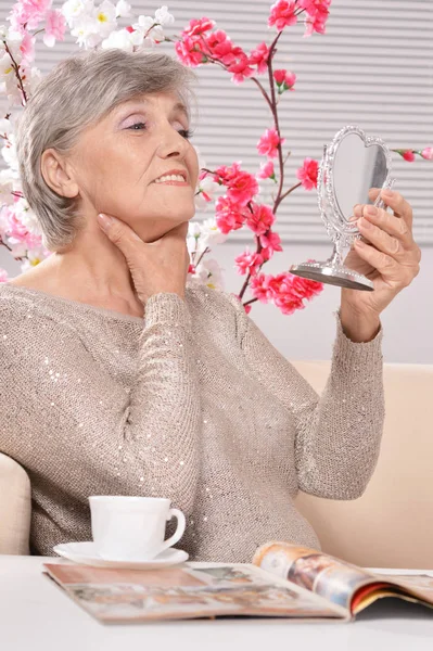Mujer envejecida mirando en el espejo — Foto de Stock