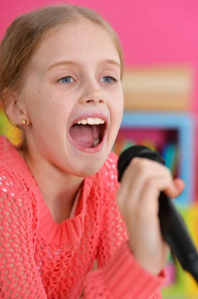 Menina cantando com microfone — Fotografia de Stock