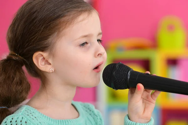 Kleines Mädchen singt mit Mikrofon — Stockfoto