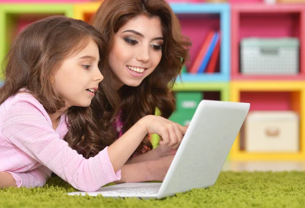Kadın ve dizüstü bilgisayar kullanan küçük kız — Stok fotoğraf