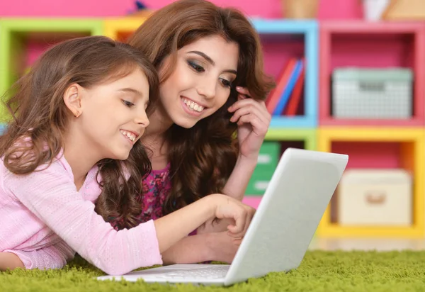 Kadın ve dizüstü bilgisayar kullanan küçük kız — Stok fotoğraf