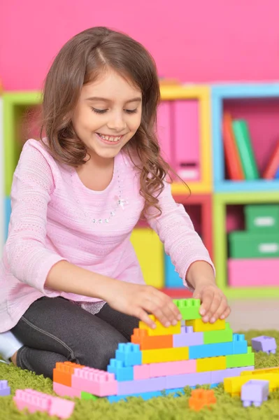 Linda chica jugando con bloques de plástico — Foto de Stock