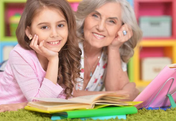 Flicka och mormor göra läxor — Stockfoto