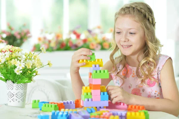 Kleines Mädchen mit bunten Plastikklötzen — Stockfoto