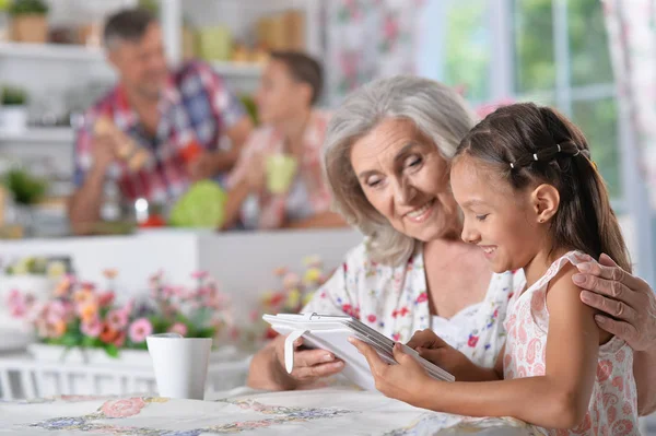 Menina com avó usando tablet — Fotografia de Stock