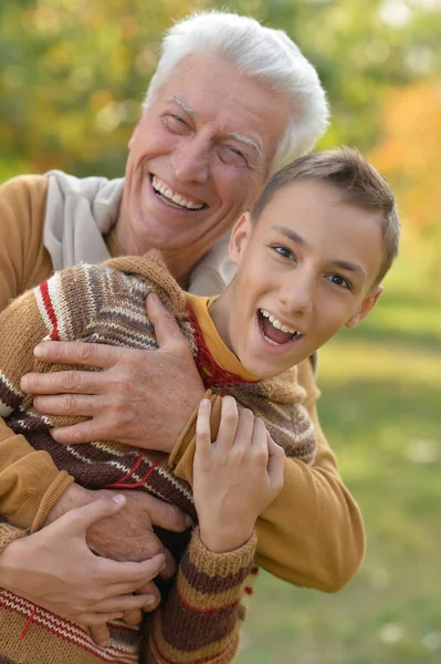 Дедушка и внук обнимаются в парке — стоковое фото