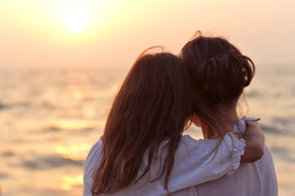 Madre e hija de pie en la orilla del mar — Foto de Stock