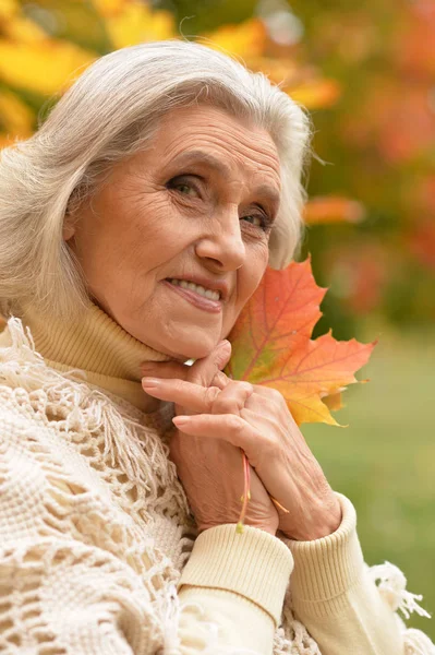 Frau hält Herbstlaub in der Hand — Stockfoto