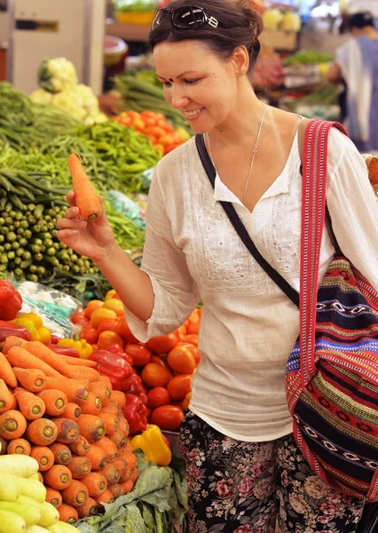 女を市場で野菜を選ぶ — ストック写真