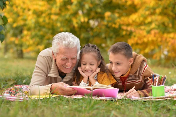 Kinderen en grootvader huiswerk — Stockfoto