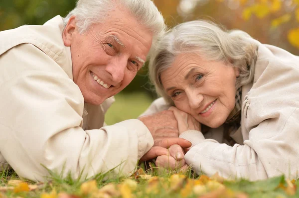 Couple in autumn park lying — Stock Photo, Image