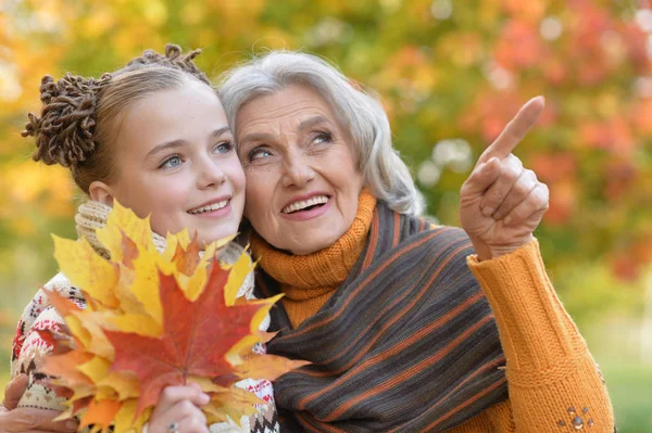 Oma en kleindochter poseren buitenshuis — Stockfoto