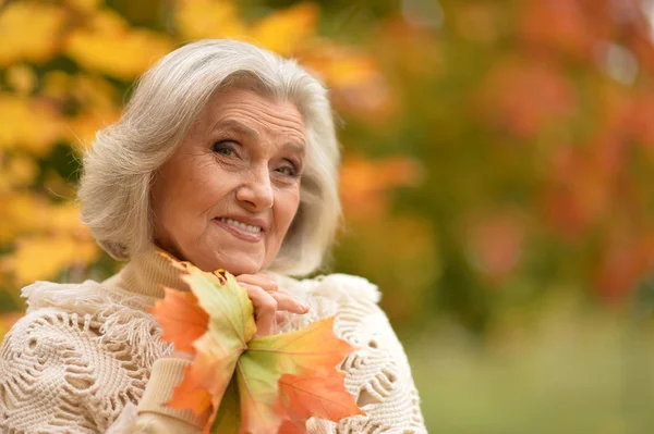 Donna che tiene foglie autunnali — Foto Stock