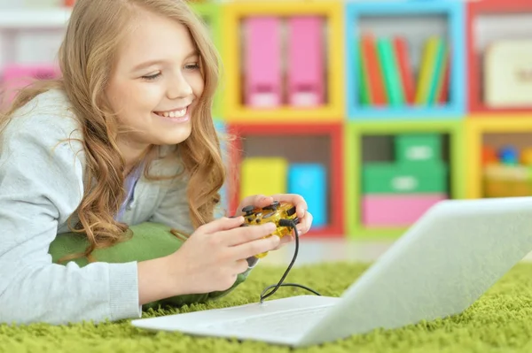 Маленькая девочка играет на ноутбуке — стоковое фото