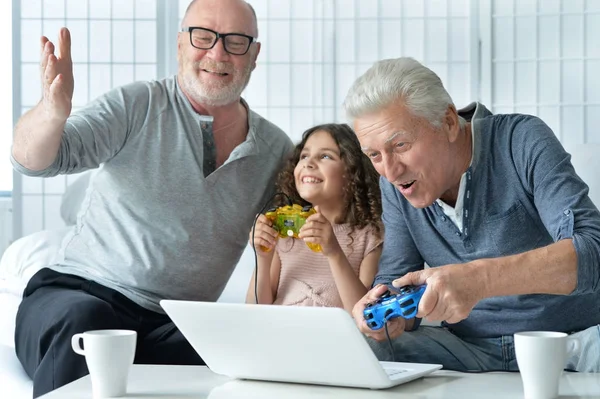 Senior mannen met kleindochter spelen op laptop — Stockfoto