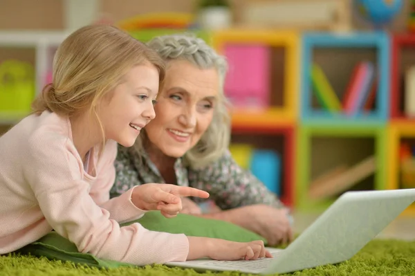 Chica con la abuela usando el ordenador portátil — Foto de Stock