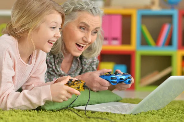 Бабушка и внучка играют на ноутбуке — стоковое фото