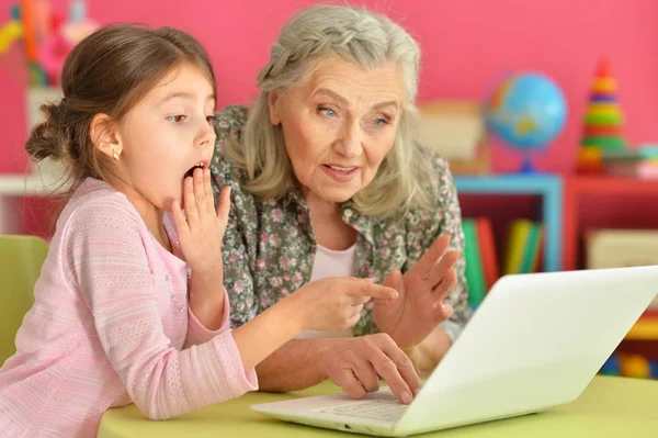 Meisje met grootmoeder met behulp van laptop — Stockfoto