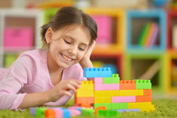 Kleines Mädchen mit bunten Plastikklötzen — Stockfoto